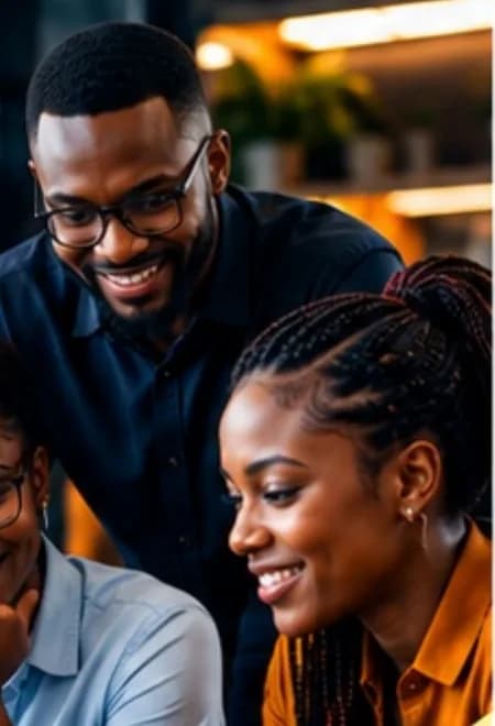 Trois collaborateurs souriants autour d'un ordinateur portable